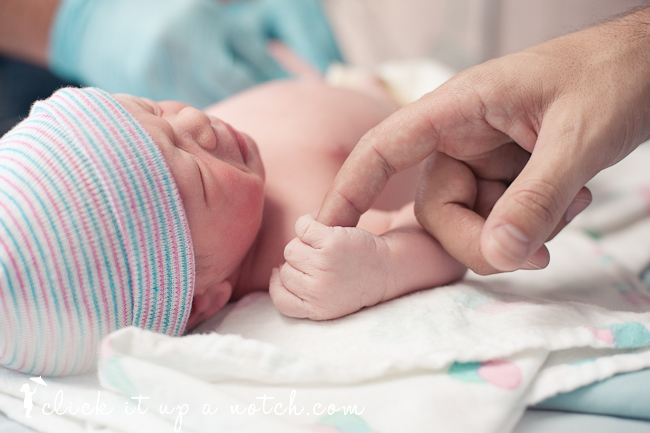 Detailed shot of the baby holding dad's finger.
